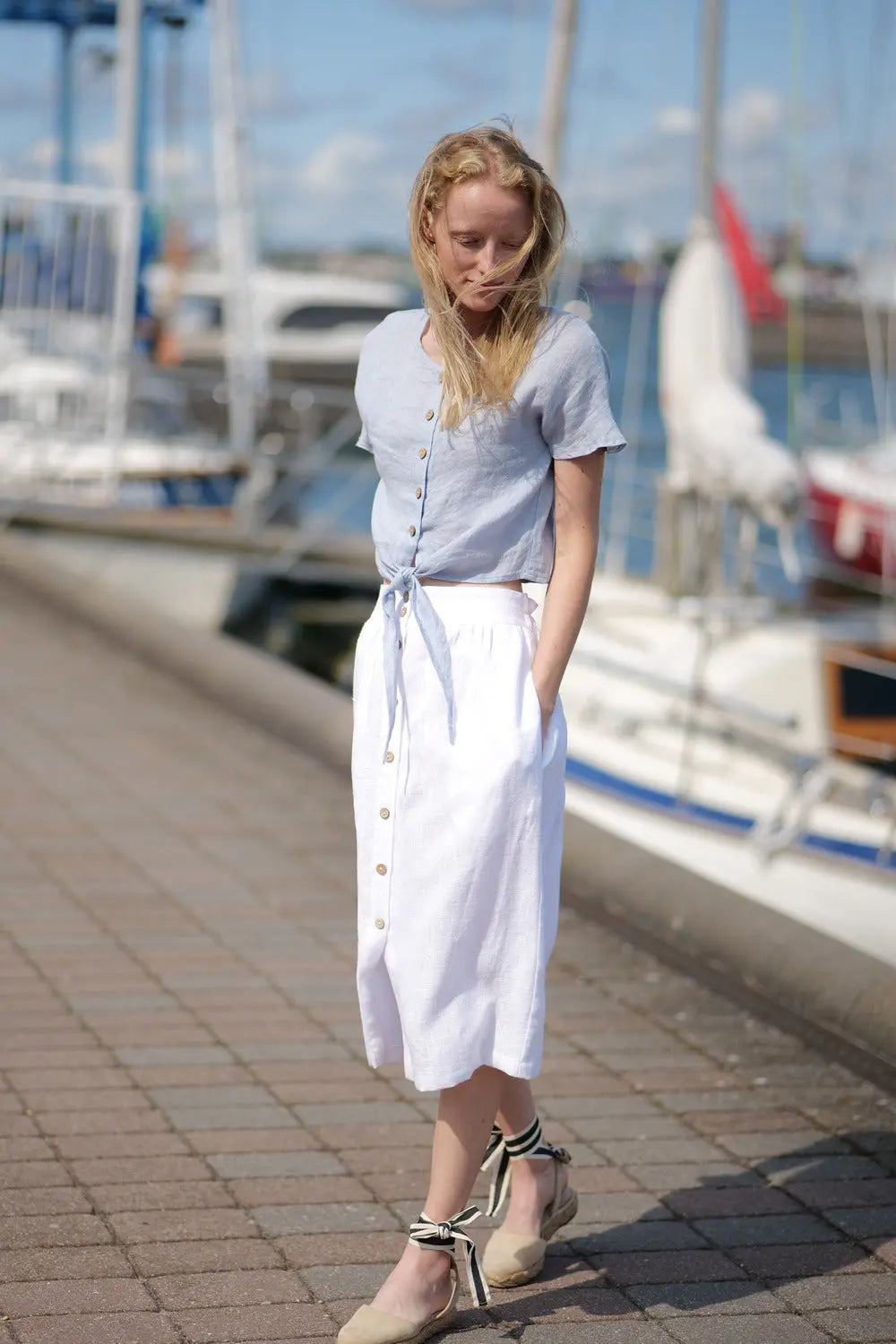 Summer outfit with short-sleeved linen top and high-waisted white skirt.