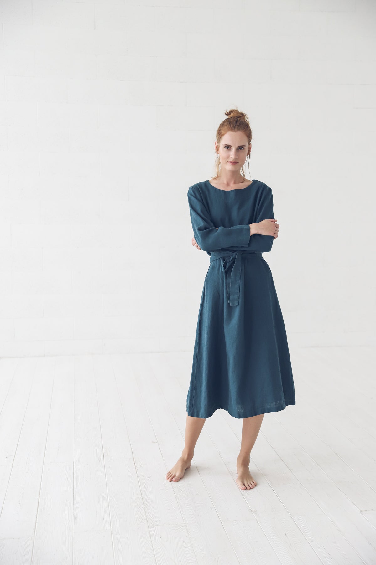 woman wearing a stylish linen dress in a shaded spruce color