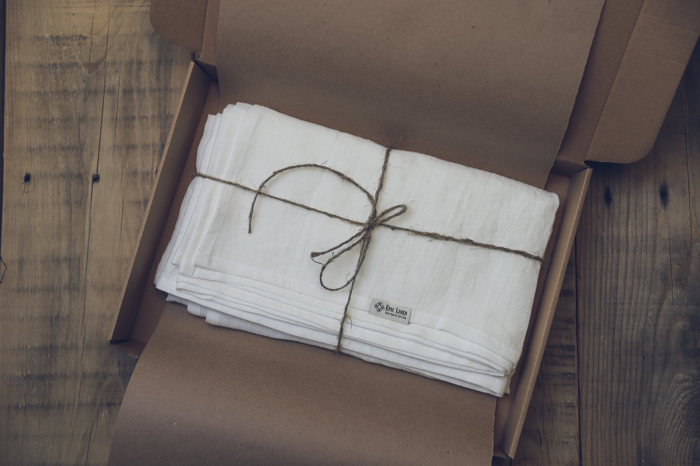 white linen wrapped in twine, kraft paper and an eco box