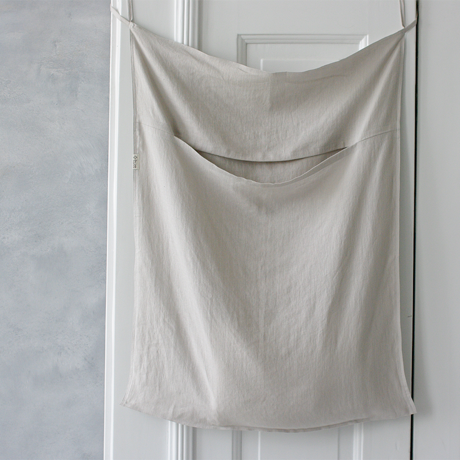 A white hanging linen laundry bag