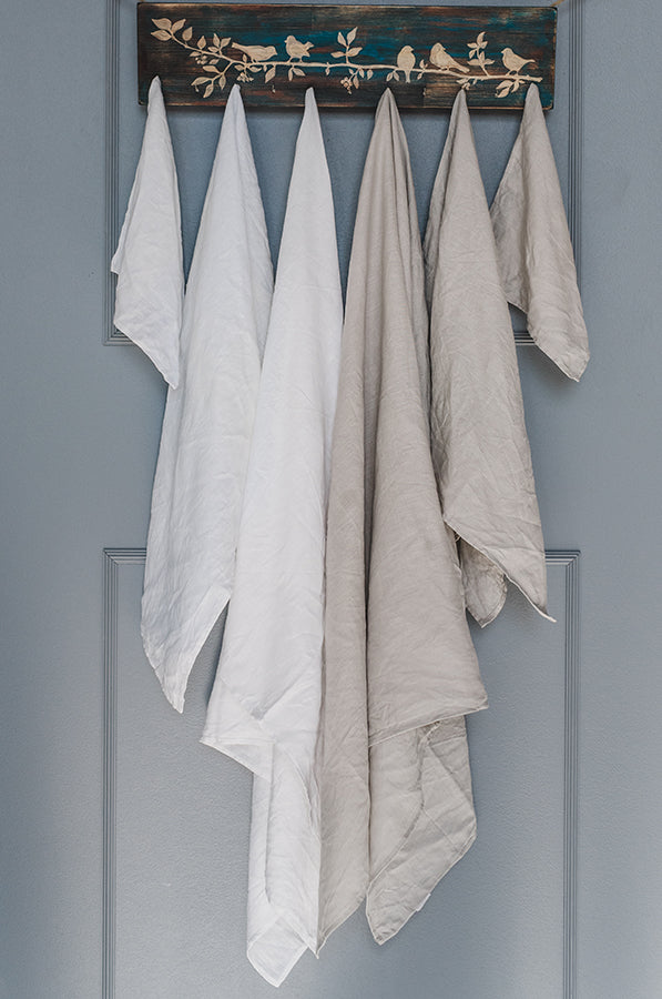 white and natural linen towels hanging in a bathroom
